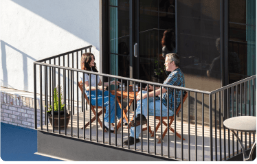 Two people relaxing on an apartment balcony