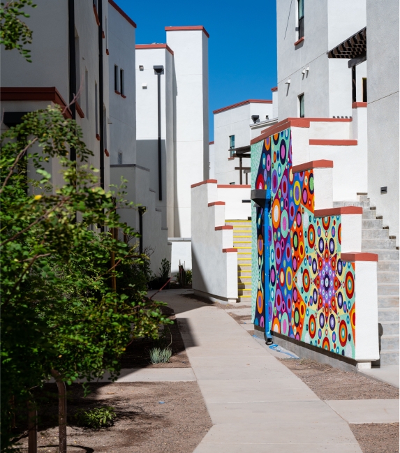 Walkway lined with trees and mural